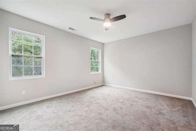 carpeted spare room with ceiling fan