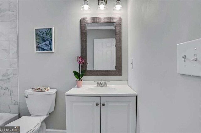 full bathroom featuring toilet, vanity, and tiled shower / bath