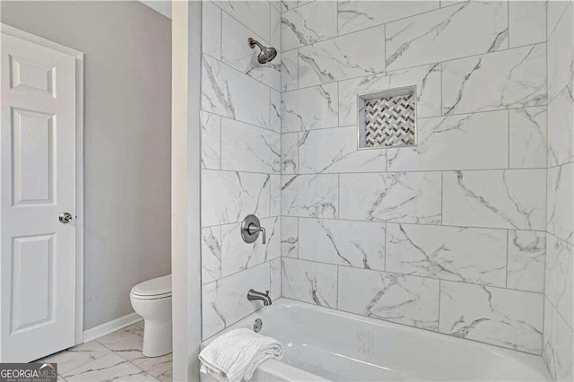 bathroom featuring toilet, tiled shower / bath combo, and tile patterned flooring