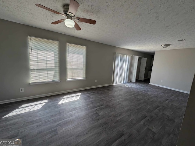 empty room with a textured ceiling, dark hardwood / wood-style floors, and ceiling fan