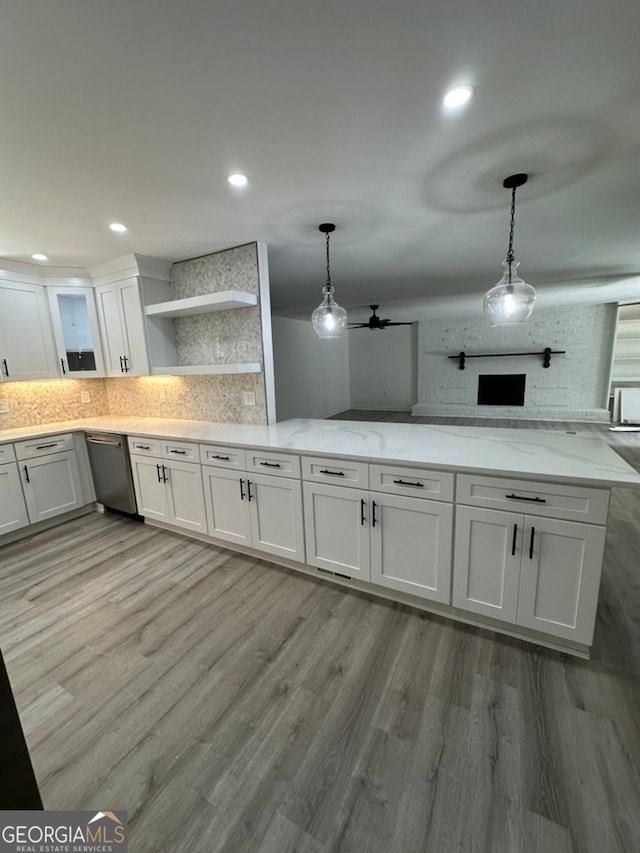 kitchen with white cabinetry, ceiling fan, hanging light fixtures, and stainless steel dishwasher