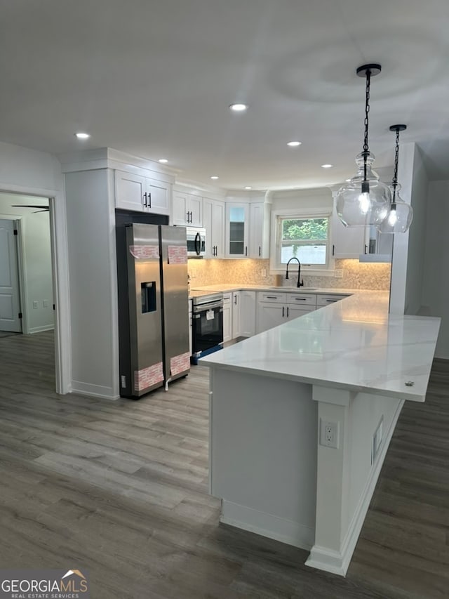 kitchen featuring hanging light fixtures, white cabinetry, dark hardwood / wood-style floors, and stainless steel appliances