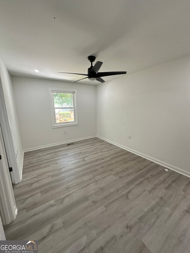 spare room with ceiling fan and light wood-type flooring