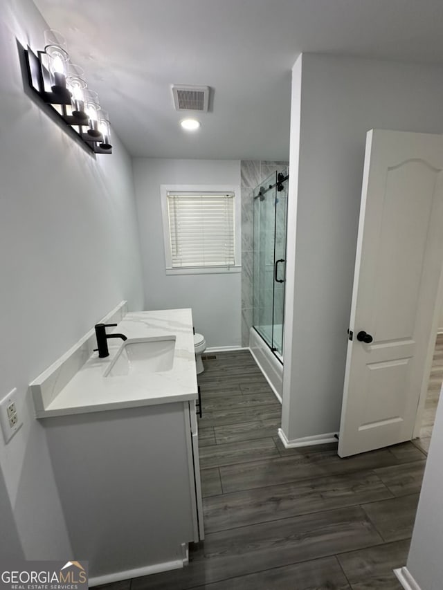 bathroom with walk in shower, vanity, toilet, and hardwood / wood-style flooring