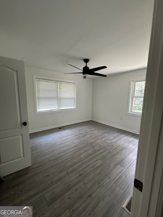 unfurnished room with ceiling fan and dark hardwood / wood-style flooring