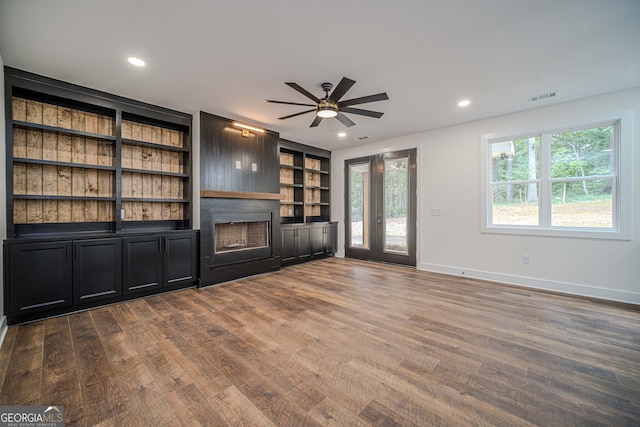 unfurnished living room with ceiling fan and wood-type flooring