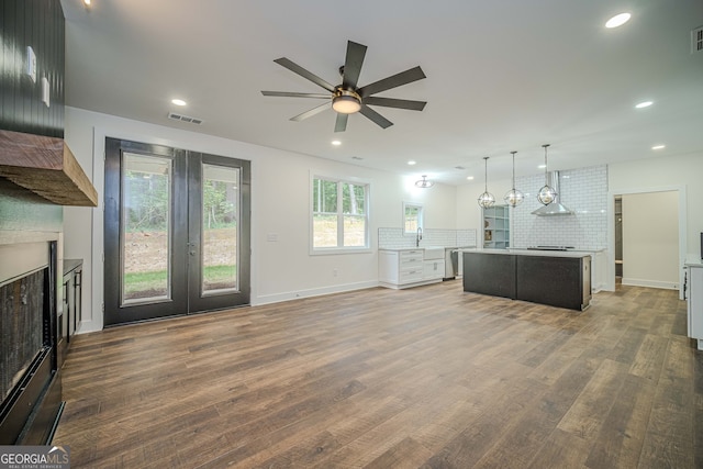 unfurnished living room with ceiling fan, wood-type flooring, sink, and french doors