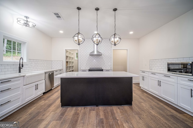 kitchen featuring backsplash, decorative light fixtures, a kitchen island, and stainless steel appliances