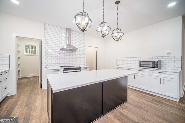 kitchen with decorative backsplash, wall chimney exhaust hood, decorative light fixtures, an inviting chandelier, and white cabinetry