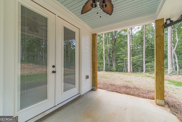 unfurnished sunroom with ceiling fan, wooden ceiling, and french doors