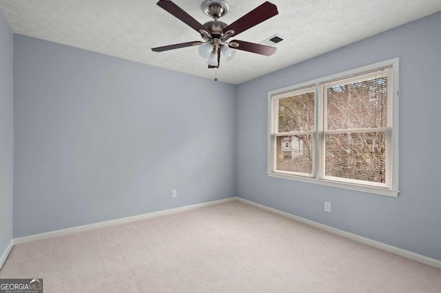 empty room with ceiling fan, a textured ceiling, and carpet