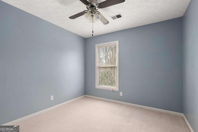 spare room with ceiling fan, a textured ceiling, and carpet flooring