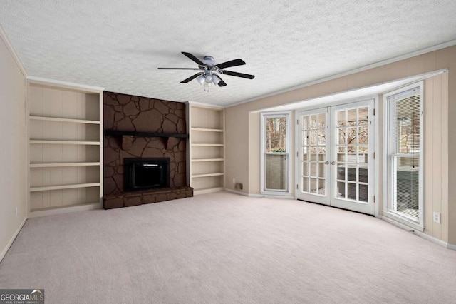 unfurnished living room featuring ceiling fan, a textured ceiling, and light colored carpet