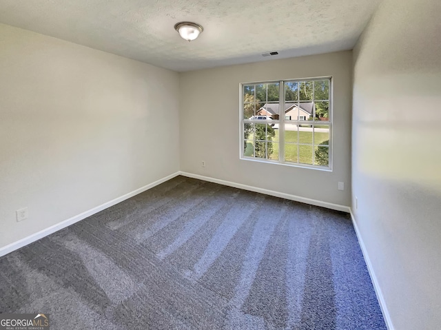 carpeted spare room featuring a textured ceiling