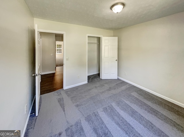 unfurnished bedroom with a closet, carpet floors, and a textured ceiling