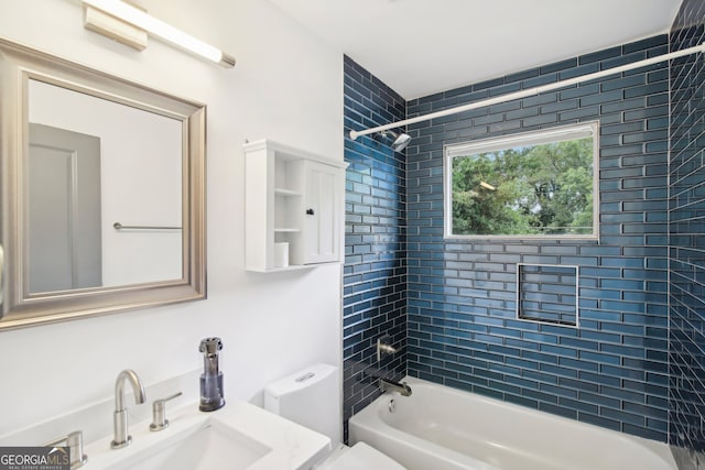 full bathroom featuring tiled shower / bath combo, toilet, and sink