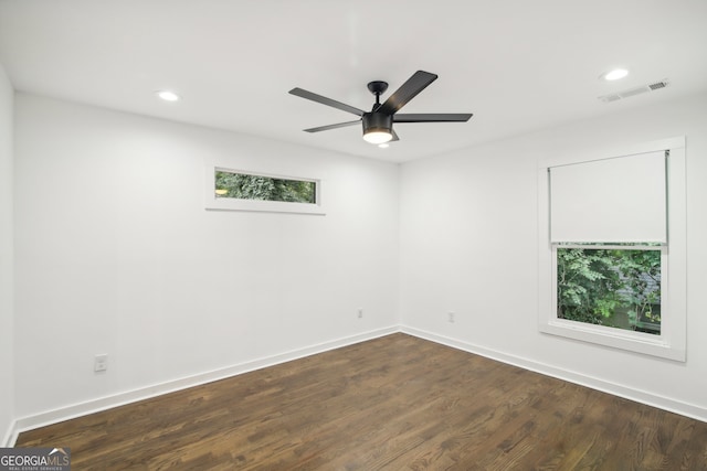 spare room with plenty of natural light, ceiling fan, and dark hardwood / wood-style flooring