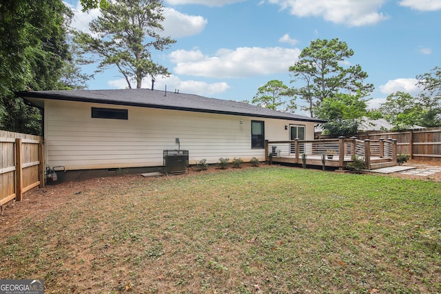 rear view of house with a lawn and a wooden deck