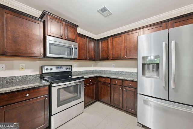 kitchen featuring dark stone counters, dark brown cabinets, appliances with stainless steel finishes, and crown molding