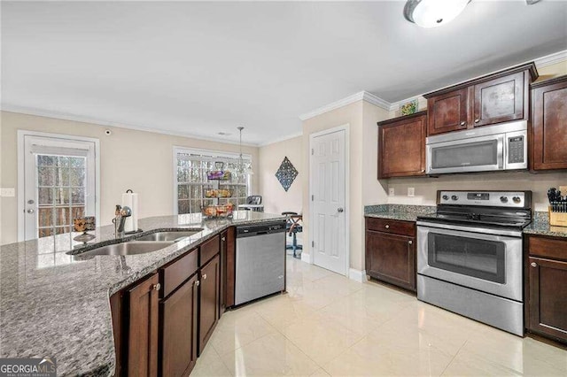 kitchen featuring pendant lighting, ornamental molding, sink, stainless steel appliances, and dark stone countertops