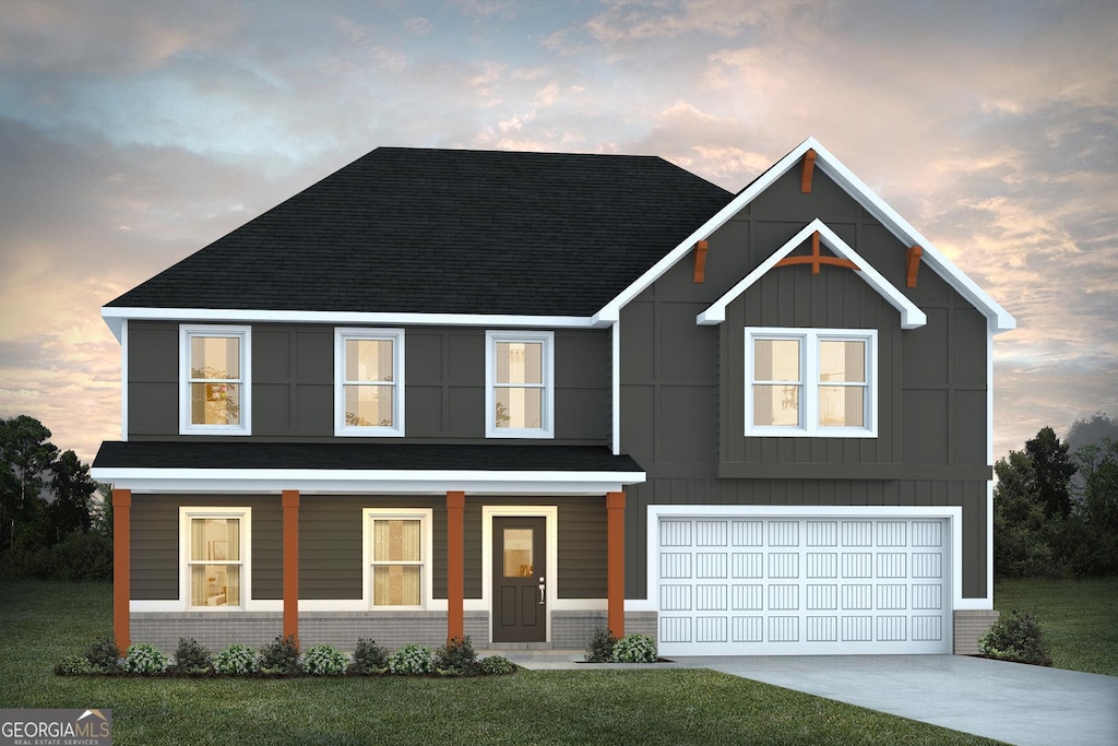 view of front facade featuring board and batten siding, a front lawn, concrete driveway, and brick siding