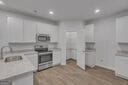 713 Windstream Dr Unit B58, Lagrange, GA 30241 - kitchen featuring light countertops, recessed lighting, a fireplace, a sink, and white cabinets