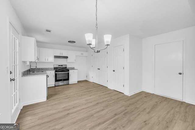 kitchen with pendant lighting, sink, white cabinets, stainless steel gas range oven, and light wood-type flooring