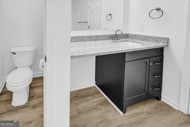 bathroom with vanity, hardwood / wood-style floors, and toilet