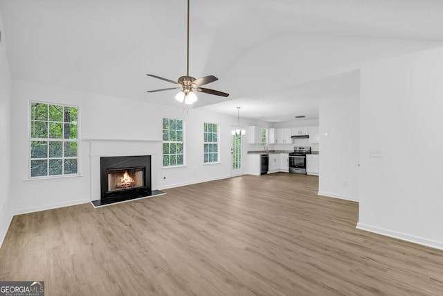 unfurnished living room with ceiling fan, lofted ceiling, a high end fireplace, and light hardwood / wood-style floors