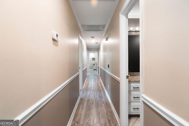 corridor featuring light wood finished floors and visible vents