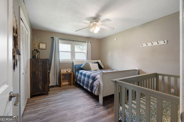 bedroom featuring ceiling fan, a textured ceiling, a closet, and hardwood / wood-style floors