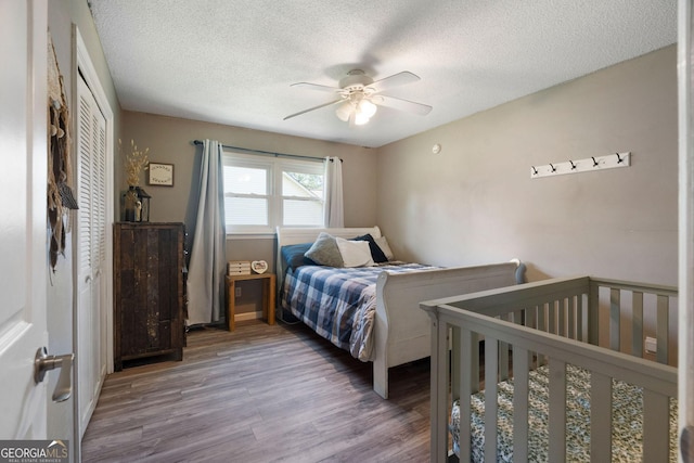 bedroom featuring a textured ceiling, ceiling fan, a closet, and wood finished floors