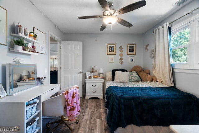 bedroom with ceiling fan, visible vents, and dark wood-type flooring