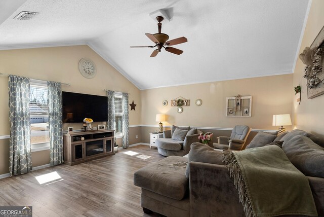 living room with ornamental molding, ceiling fan, vaulted ceiling, and dark hardwood / wood-style floors