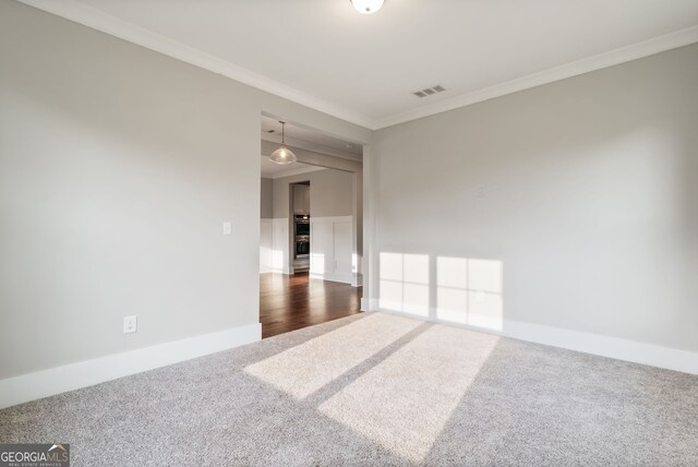 spare room with crown molding and dark wood-type flooring