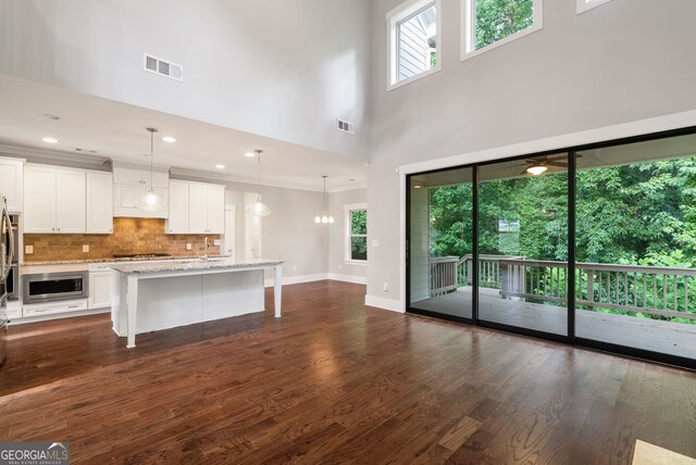 kitchen with dark wood-type flooring, a breakfast bar, pendant lighting, and a wealth of natural light