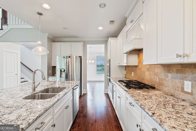 kitchen with pendant lighting, dark hardwood / wood-style floors, appliances with stainless steel finishes, sink, and backsplash