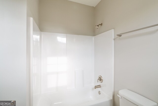 bathroom with washtub / shower combination and toilet