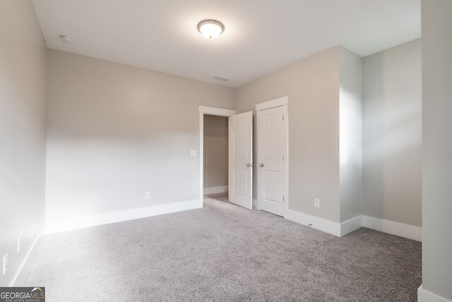 unfurnished bedroom featuring a closet and light colored carpet