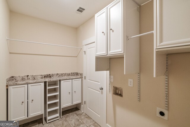 clothes washing area with light tile patterned floors, cabinets, hookup for an electric dryer, and washer hookup