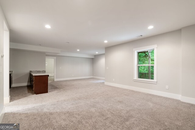 basement featuring light carpet