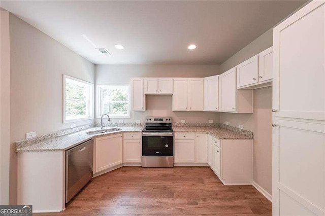 kitchen featuring light wood-type flooring, sink, stainless steel appliances, and light stone countertops