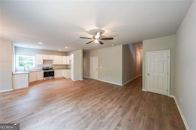 unfurnished living room with ceiling fan and light hardwood / wood-style flooring