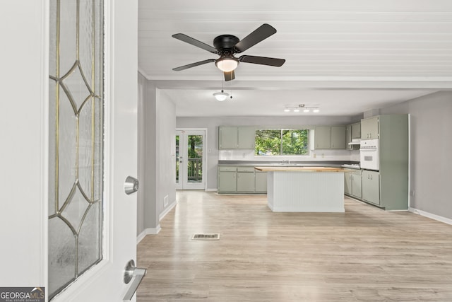 kitchen featuring gray cabinets, a center island, light hardwood / wood-style flooring, and oven