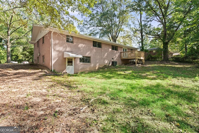 rear view of house featuring a deck, a lawn, and central AC unit