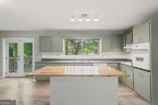 kitchen featuring a healthy amount of sunlight, a kitchen island, and white appliances