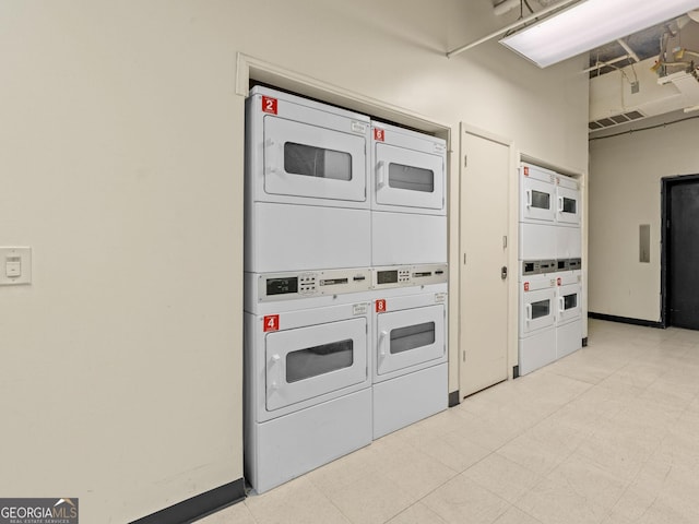 laundry room with light tile patterned floors and stacked washer and clothes dryer