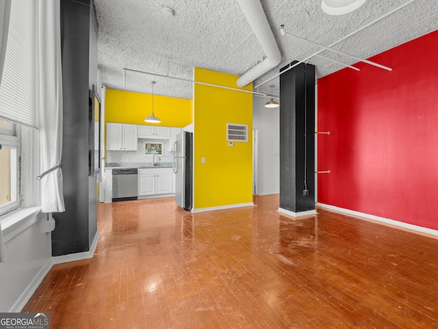 unfurnished living room with sink and hardwood / wood-style floors