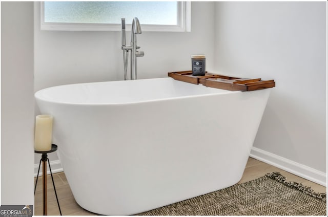 interior details with wood-type flooring, sink, and a washtub