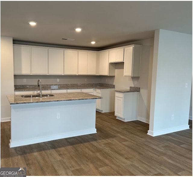 kitchen featuring white cabinetry, sink, a kitchen island with sink, and dark hardwood / wood-style floors